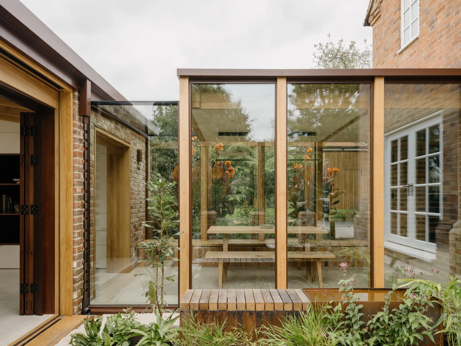 Timber-framed glazing around the planted courtyard at Muttram Veedu.