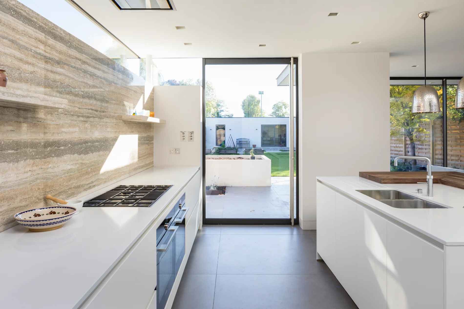 S-Max aluminium pivot door viewed through a bright kitchen towards a garden
