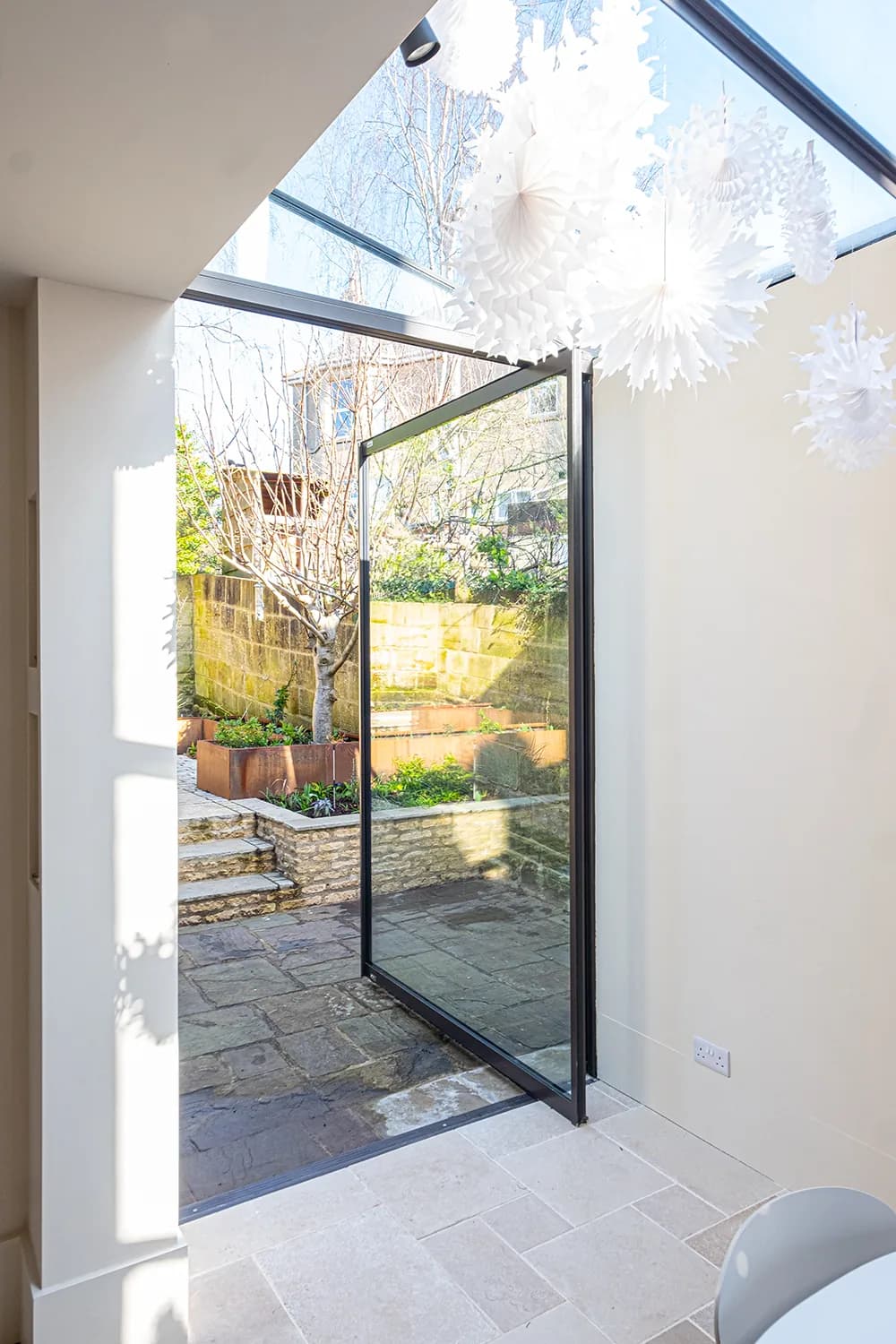 Bright rear extension with lean-to glazing above a garden doorway