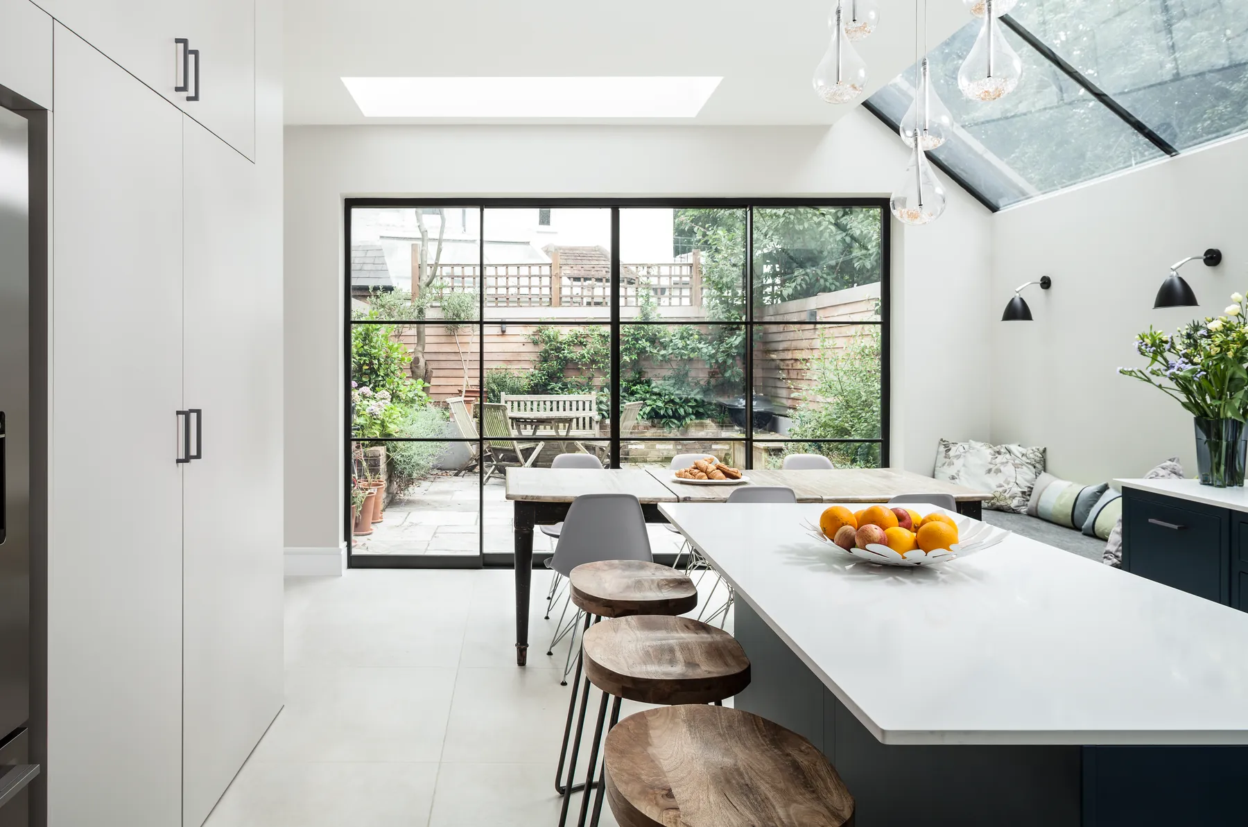 Kitchen island below a lean-to glazed side return and steel-framed doors