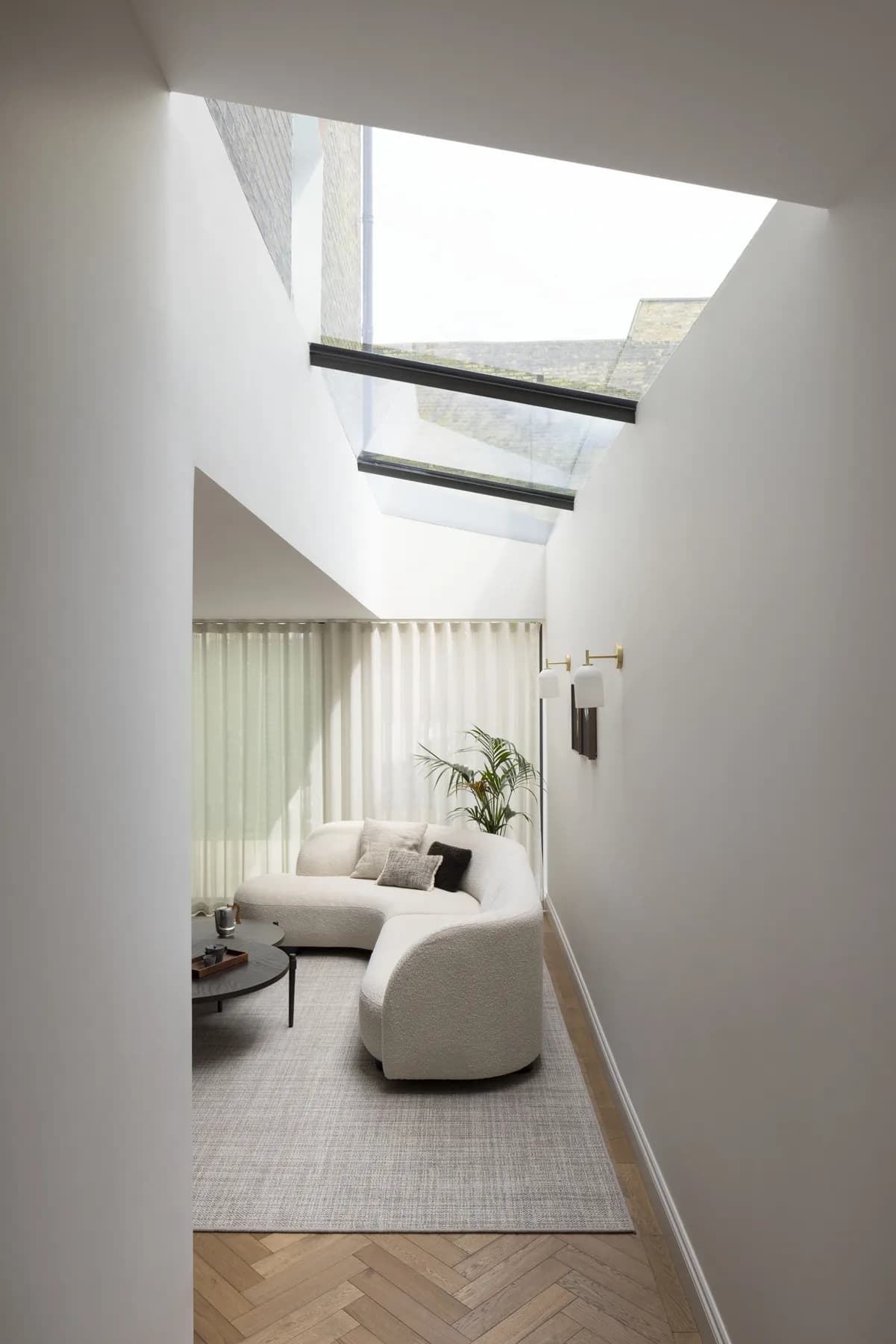 Living room with a lean-to rooflight set above a calm seating area