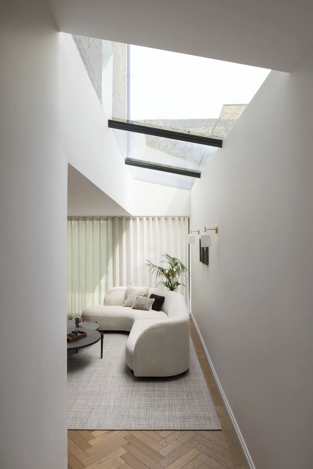 Living room with a lean-to rooflight set above a calm seating area