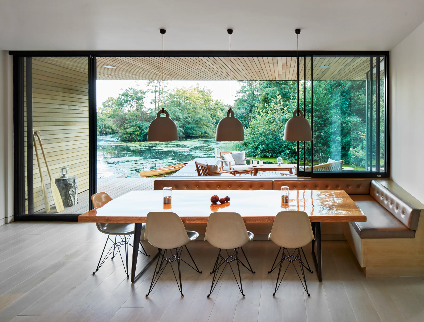Wide sliding window connecting a dining room with a green terrace
