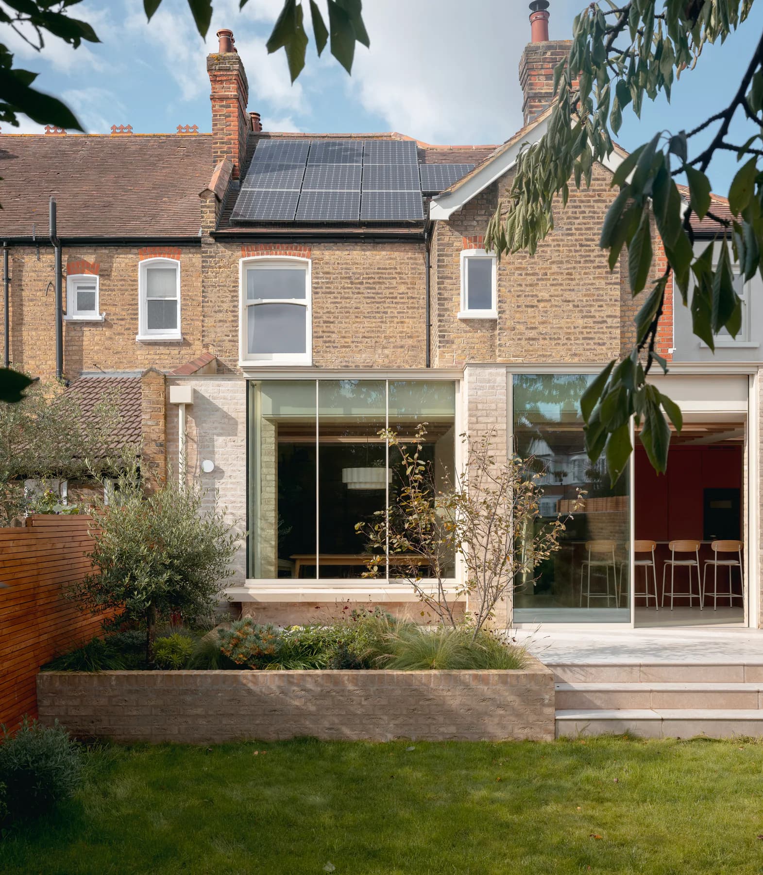 Broad aluminium sliding window across the rear of a brick London home